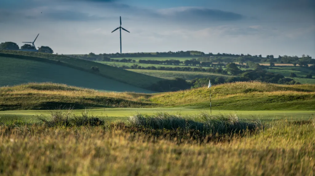 Rolling links greens and fescue under a wide evening sky